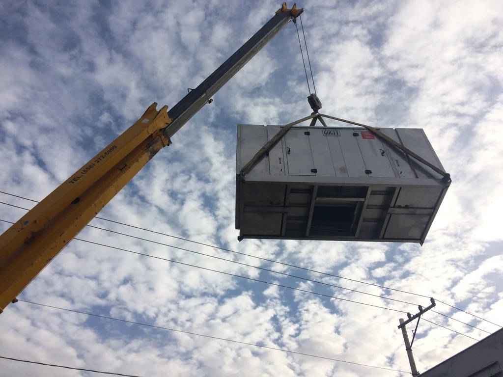 Izaje con grúa de un equipo industrial durante su instalación