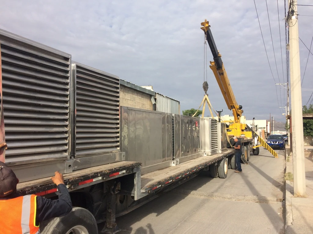 Equipo industrial Gogui sobre plataforma de transporte durante una maniobra con grúa